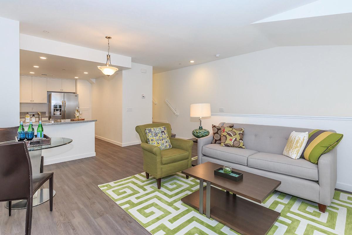 2-bedroom-townhomes-in-chula-vista-ca-contessa-at-otay-ranch-a-modern-living-room-with-a-gray-sofa-a-wooden-coffee-table-and-wood-style-flooring-9526077